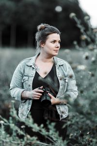 Portraitshooting: junge Frau mit Kamera im Feld