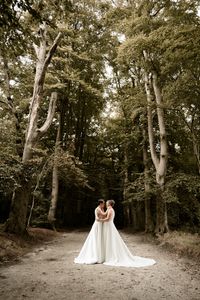 Hochzeitsfotografie: Braeute stehen in einer hellen Waldlichtung